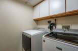 This laundry room features a spacious layout with two modern washing machines, including a Maytag model, ready for your laundry needs.