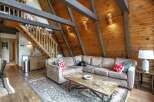 Experience rustic charm in this cozy living room, featuring a plush sectional sofa perfect for relaxation.