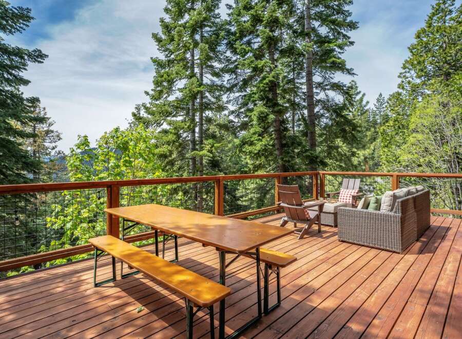 Enjoy the serene mountain views from this spacious wooden deck, perfect for outdoor dining and relaxation.