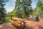 Enjoy the serene mountain views from this spacious wooden deck, perfect for outdoor dining and relaxation.