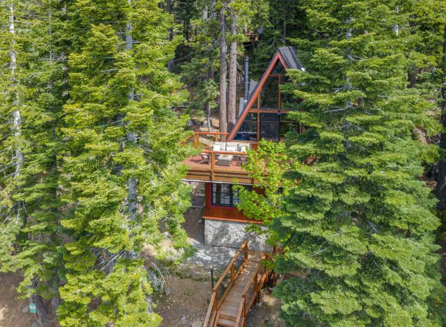 Nestled amidst lush evergreen trees, this modern A-frame cabin offers a serene mountain retreat.