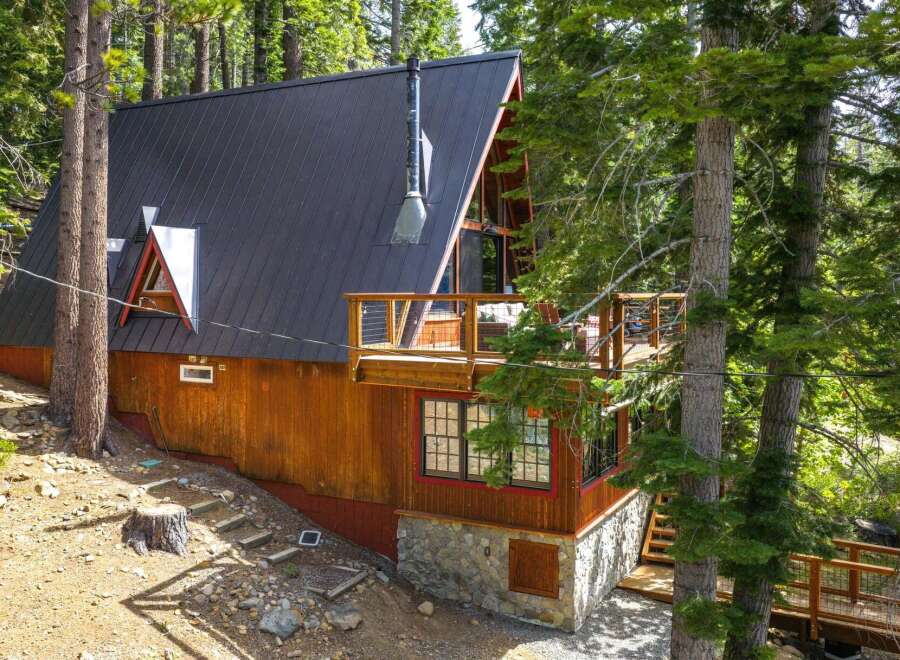 Nestled amidst towering trees, this charming A-frame cabin offers a serene mountain retreat.