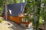 Nestled amidst towering trees, this charming A-frame cabin offers a serene mountain retreat.