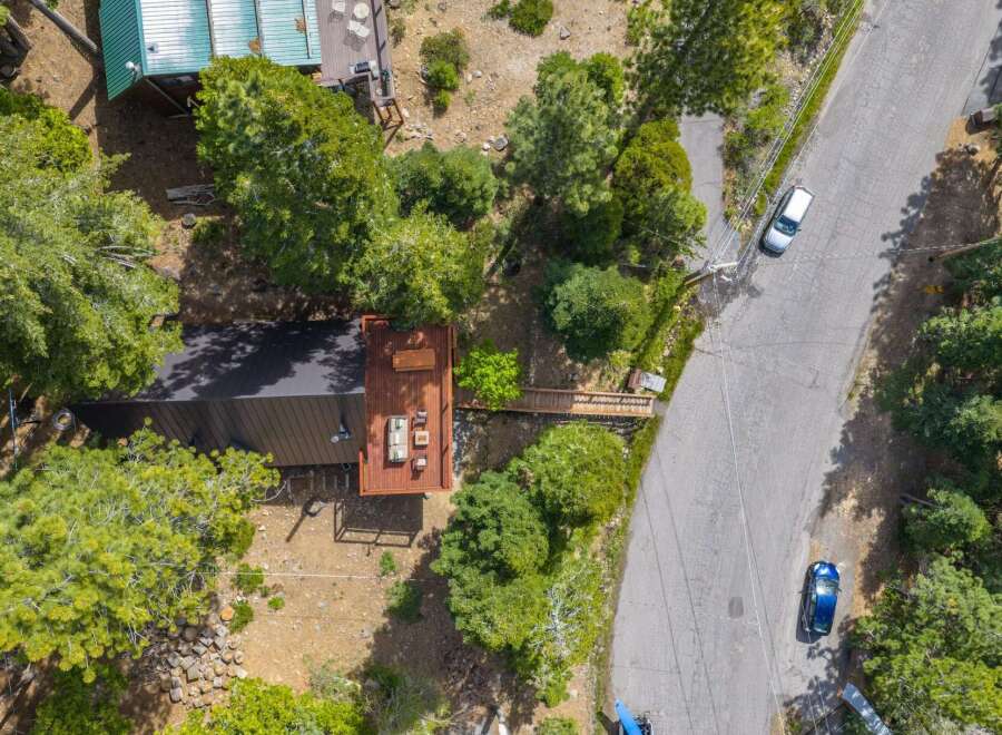 Discover this charming property featuring a modern dark-roofed home with an expansive wooden deck, perfect for outdoor living and entertaining.
