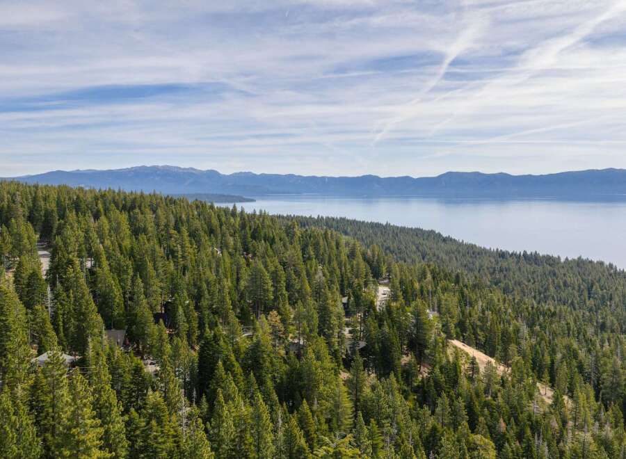 Discover breathtaking lake and mountain views from this stunning property nestled amongst towering pine trees.