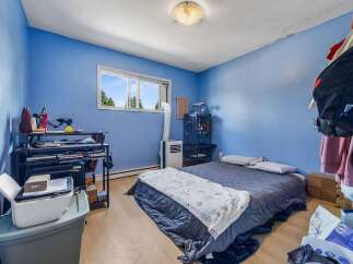 Discover this cozy bedroom featuring a comfortable bed adorned with a patterned throw blanket, perfect for relaxation.