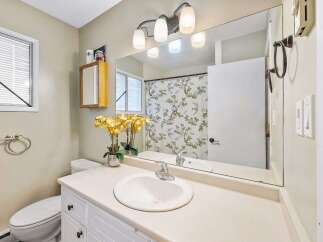 This charming bathroom features a spacious vanity with a built-in sink and ample storage, perfect for organizing your essentials.