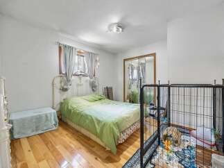 This cozy bedroom features a comfortable bed with a light green comforter, perfect for a restful night's sleep.