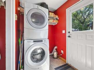 This laundry room features a stacked Whirlpool washer and dryer, perfect for maximizing space.