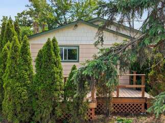 Charming home featuring a welcoming wooden deck, perfect for outdoor relaxation and entertaining.