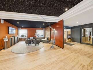 Experience modern comfort in this stylish lounge area, featuring a unique ski-lift inspired chair and a cozy, curved sofa perfect for relaxation.