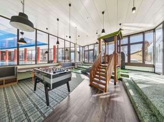 This spacious recreational area offers a perfect blend of fun and relaxation, featuring a foosball table for friendly competition and a vibrant indoor playground for children.