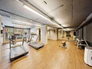 This modern gym features a variety of cardio equipment, including treadmills and an elliptical, perfect for your fitness routine.