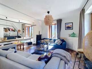 Experience rustic charm in this inviting living space, featuring a vibrant blue sofa adorned with patterned throw pillows and a cozy grey blanket.