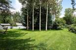 Enjoy the serene backyard oasis featuring a lush green lawn perfect for outdoor activities and relaxation.