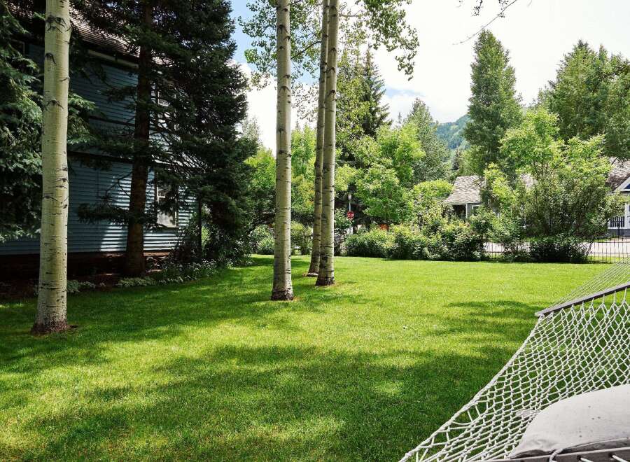 Enjoy the serene beauty of this property, featuring a lush green lawn perfect for outdoor activities and relaxation.