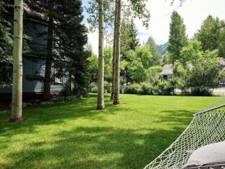 Enjoy the serene beauty of this property, featuring a lush green lawn perfect for outdoor activities and relaxation.