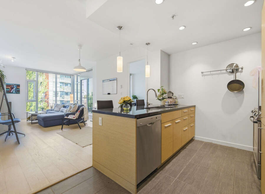 Experience modern living in this bright and airy condo, featuring an open-concept layout that seamlessly connects the living room and kitchen.