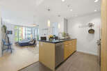 Experience modern living in this bright and airy condo, featuring an open-concept layout that seamlessly connects the living room and kitchen.