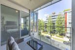Enjoy outdoor living on this spacious balcony with comfortable seating and a modern glass coffee table.