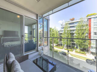 Enjoy outdoor living on this spacious balcony with comfortable seating and a modern glass coffee table.