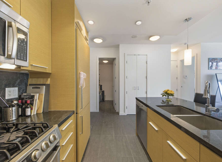 This modern kitchen boasts sleek, light wood cabinetry and a durable granite countertop.
