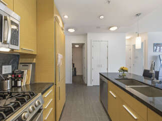 This modern kitchen boasts sleek, light wood cabinetry and a durable granite countertop.