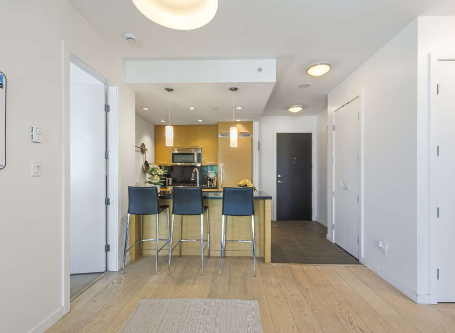 Experience modern living in this stylish condo featuring a sleek kitchen with a breakfast bar and stainless steel appliances.