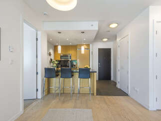 Experience modern living in this stylish condo featuring a sleek kitchen with a breakfast bar and stainless steel appliances.