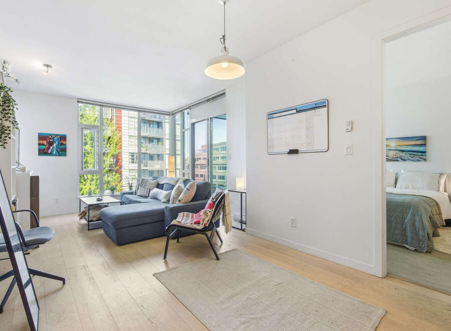 Experience modern living in this bright and airy condo featuring a spacious living area with ample natural light from floor-to-ceiling windows.