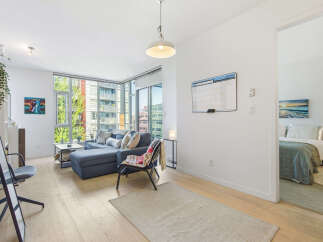 Experience modern living in this bright and airy condo featuring a spacious living area with ample natural light from floor-to-ceiling windows.