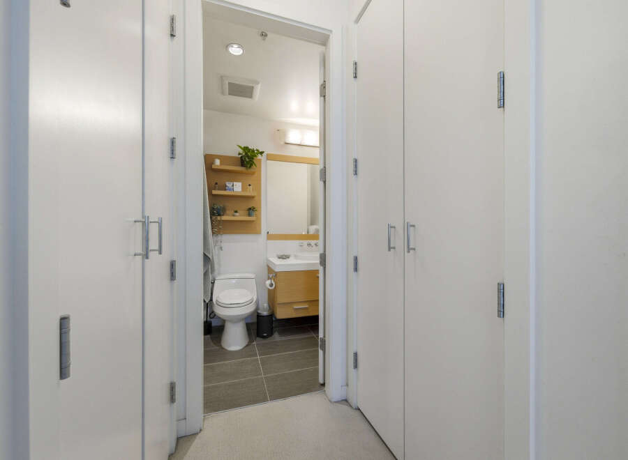 Step into a modern bathroom featuring a sleek toilet and a stylish vanity with ample storage.