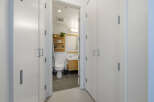 Step into a modern bathroom featuring a sleek toilet and a stylish vanity with ample storage.