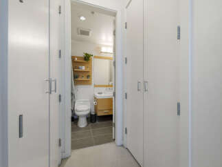 Step into a modern bathroom featuring a sleek toilet and a stylish vanity with ample storage.