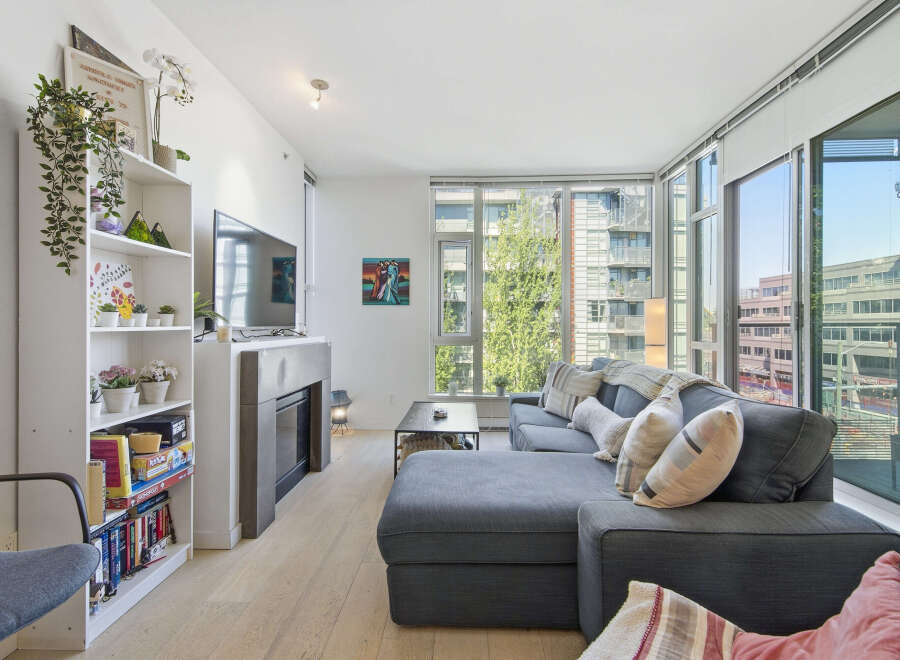 Experience modern urban living in this bright and airy condo, featuring a spacious sectional sofa perfect for relaxation and entertaining.