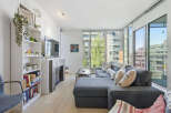 Experience modern urban living in this bright and airy condo, featuring a spacious sectional sofa perfect for relaxation and entertaining.