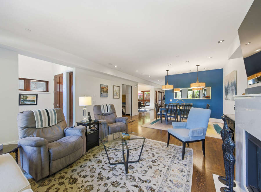 Step into this inviting living space featuring plush recliners and a stylish blue accent wall that defines the adjacent dining area.