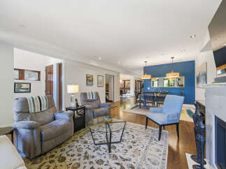 Step into this inviting living space featuring plush recliners and a stylish blue accent wall that defines the adjacent dining area.