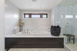 Indulge in luxury with this stunning bathroom featuring a deep soaking tub set against elegant marble countertops.
