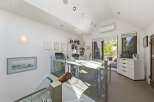 This modern home office features a sleek white desk with glass partitions, perfect for productivity.