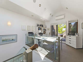 This modern home office features a sleek white desk with glass partitions, perfect for productivity.