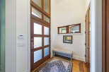 Step into this inviting entryway featuring a stunning wooden door with frosted glass panels, offering both privacy and natural light.