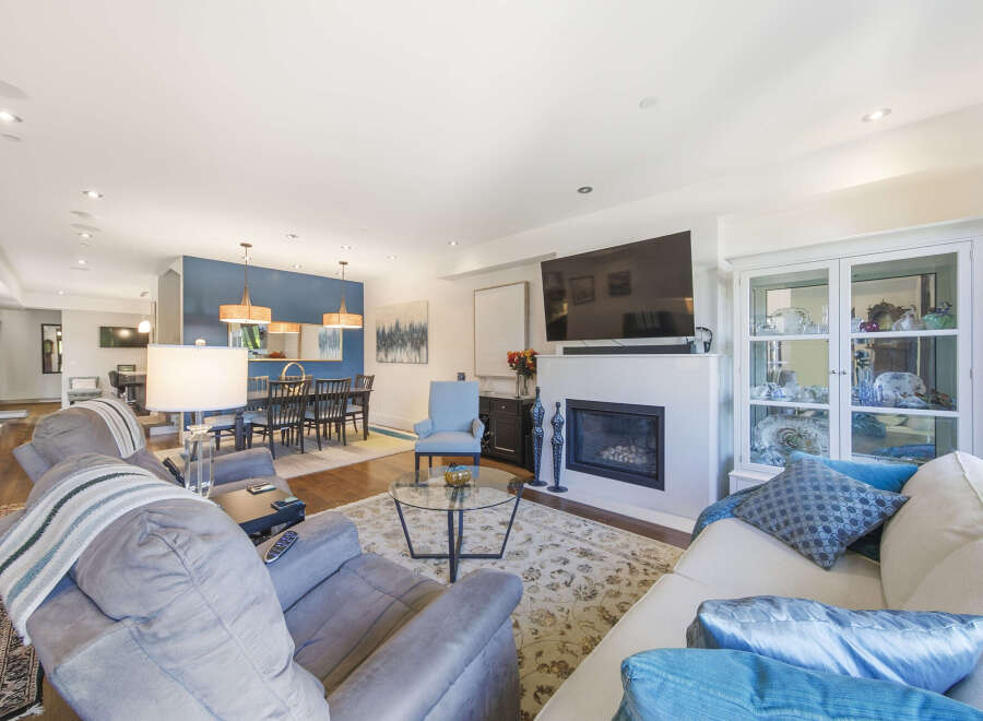 This spacious open-concept living and dining area features a modern gas fireplace as a focal point, perfect for cozy evenings.