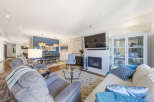This spacious open-concept living and dining area features a modern gas fireplace as a focal point, perfect for cozy evenings.