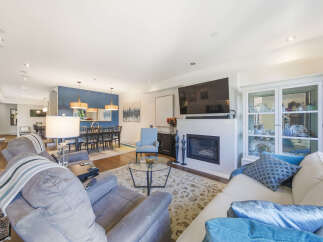 This spacious open-concept living and dining area features a modern gas fireplace as a focal point, perfect for cozy evenings.