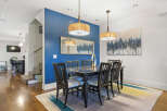 This elegant dining room features a sleek black dining table with six chairs, illuminated by two stylish pendant lights.