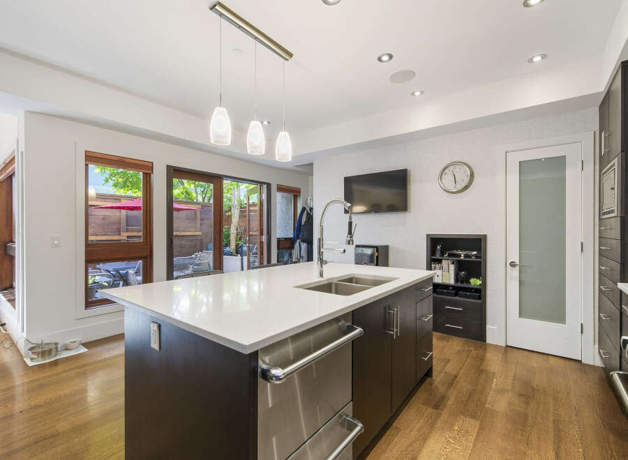 Experience modern living in this stunning kitchen featuring a large island with a double sink and sleek cabinetry.