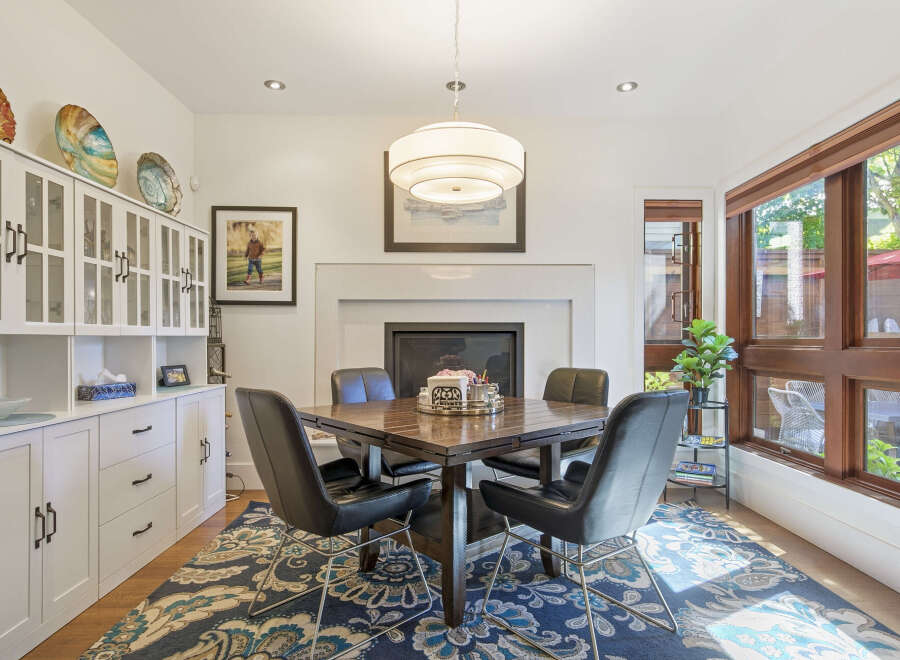 This dining room features a modern aesthetic with a dark wood dining table and sleek black chairs, perfect for intimate gatherings.