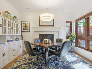 This dining room features a modern aesthetic with a dark wood dining table and sleek black chairs, perfect for intimate gatherings.