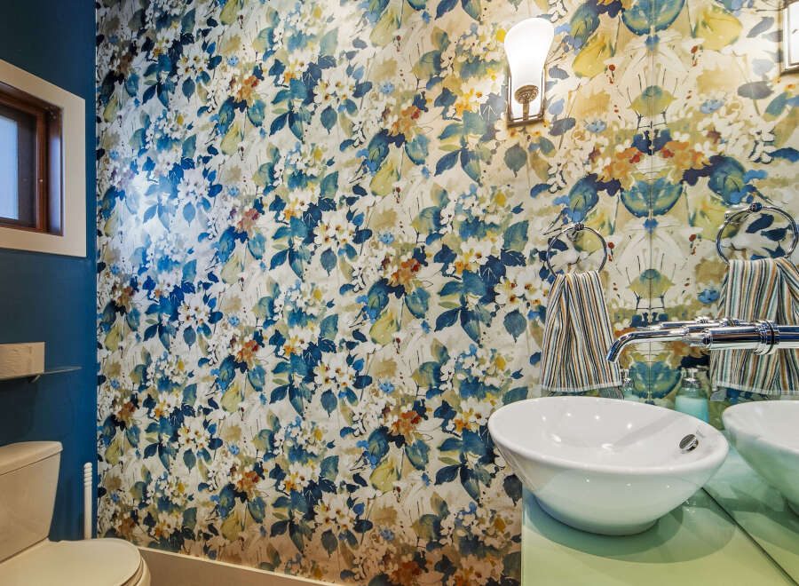 This stylish bathroom features a bold floral wallpaper that adds a vibrant touch to the space.